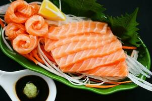 salmon sashimi food salmon fillet japanese menu with shiso perilla leaf lemon herb and spices, fresh raw salmon fish for cooking food seafood salmon fish with sauce and wasabi - top view photo