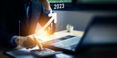 business strategy 2023, Businessman calculating business growth 2023 increase arrow graph corporate future growth year, business trend, Business annual plan and development for achieving goals. photo