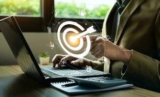 Business goals and marketing strategies. Businessman selecting target icon on laptop. economic analysis, Company strategy development, Manage and solve problems, success. business background photo