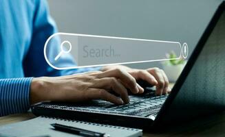 Businessman hand using laptop or computer to search information on internet social media web with search box icon and copy space. search engine information search technology photo