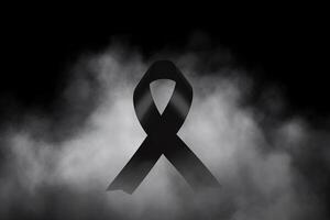 Black mourning ribbon with a dark smoke background. photo