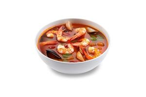 Delicious a bowl of Thai soup Tom Yam Kung with shrimps and clams isolated on white background. photo