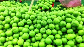 pilha do maduro verde ameixas ser vendido dentro uma público mercado video