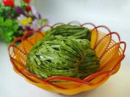 Dried green spinach noodles in small basket isolated on white background. photo