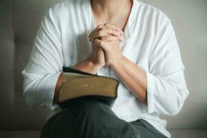 Christian life crisis prayer to god. Woman Pray for god blessing to wishing have a better life. woman hands praying to god with the bible. begging for forgiveness and believe in goodness. photo