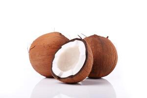 a whole and a half coconut on a white surface. photo