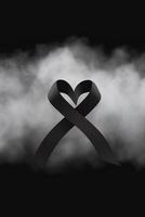 Black mourning ribbon with a dark smoke background. photo
