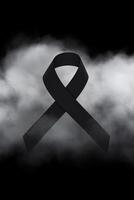 Black mourning ribbon with a dark smoke background. photo