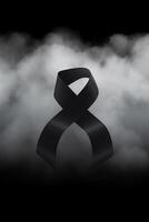 Black mourning ribbon with a dark smoke background. photo