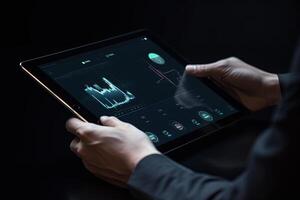 Business person analyzing stock market data on tablet with dark background. photo