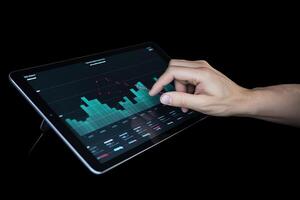 Business person analyzing stock market data on tablet with dark background. photo