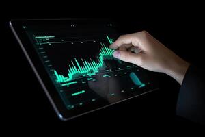 Business person analyzing stock market data on tablet with dark background. photo