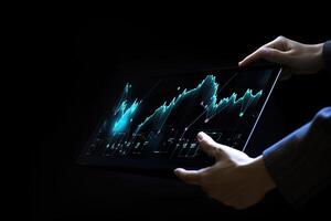 Business person analyzing stock market data on tablet with dark background. photo