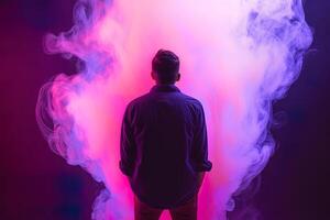 a man standing in front of a cloud of smoke with neon lights. photo