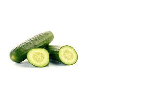 A pile of fresh whole and sliced green cucumbers isolated on white background with copy space. photo