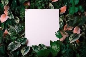 White paper card on lay green leaves texture top view background. Creative layout in nature concept. photo