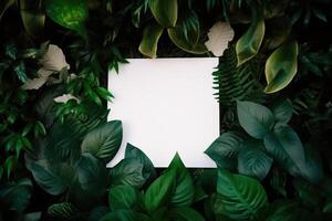 White paper card on lay green leaves texture top view background. Creative layout in nature concept. photo