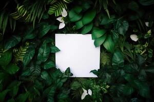 White paper card on lay green leaves texture top view background. Creative layout in nature concept. photo