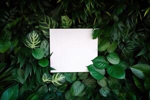 White paper card on lay green leaves texture top view background. Creative layout in nature concept. photo