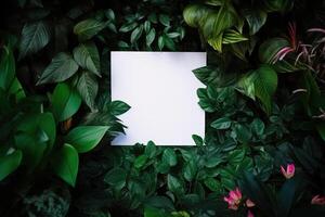 White paper card on lay green leaves texture top view background. Creative layout in nature concept. photo