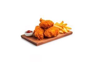 Crispy delicious fried chicken and french fries with sauce on a rectangular wooden board isolated on white background. photo