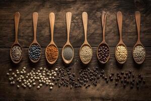 Assortment of legumes in wooden spoons on wooden background.. photo
