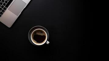 Laptop and coffee cup on black background. Top view with copy space. photo