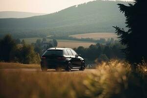 A black car on the road against the backdrop of a beautiful rural landscape with copy space photo