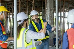 Team of engineer, architect, contractor and foreman meeting and consulting in construction building site for inspection in real estate development project industry and specification quality control photo