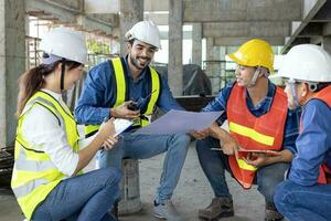 equipo de ingeniero, arquitecto, contratista y capataz reunión y consultante a el construcción edificio sitio con piso plan para real inmuebles desarrollo proyecto industria y alojamiento cronograma uso foto