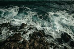 Aerial view of waves crashing against the rocks in the ocean. photo