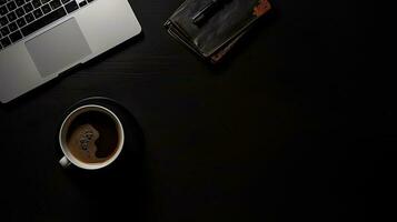 Laptop and coffee cup on black background. Top view with copy space photo