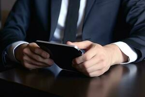 Businessman using mobile phone with blank screen sitting at office desk. photo
