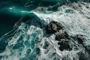 aéreo ver de olas estrellarse en contra el rocas en el océano. foto