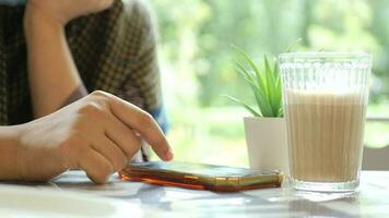 Young woman using smart phone on cafe table video