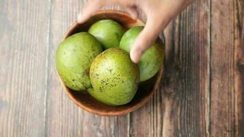 hand- plukken vers groen mango in een kom Aan tafel video