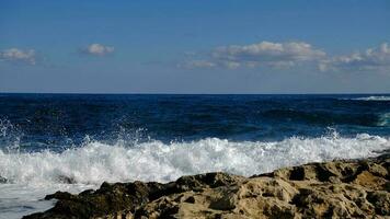 Blue sea wave and white foam and splash. Stone beach on island of Malta, no sandy beach. Summer holiday border frame concept. Tropical island vacation backdrop. Tourist travel banner design template. photo