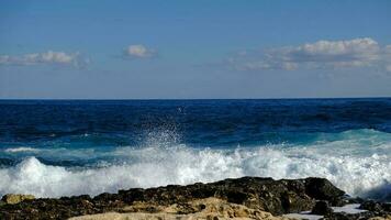 Blue sea wave and white foam and splash. Stone beach on island of Malta, no sandy beach. Summer holiday border frame concept. Tropical island vacation backdrop. Tourist travel banner design template. photo