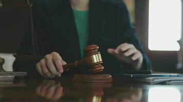 Justice and law concept.Male judge in a courtroom with the gavel, working with, computer and docking keyboard, eyeglasses, on table in morning light video