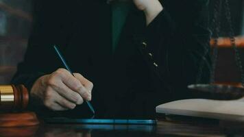 Business and lawyers discussing contract papers with brass scale on desk in office. Law, legal services, advice, justice and law concept picture with film grain effect video