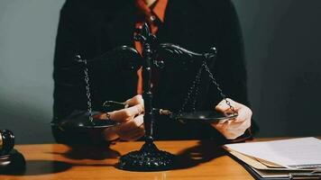 Business and lawyers discussing contract papers with brass scale on desk in office. Law, legal services, advice, justice and law concept picture with film grain effect video