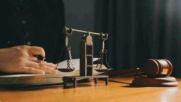 Business and lawyers discussing contract papers with brass scale on desk in office. Law, legal services, advice, justice and law concept picture with film grain effect video