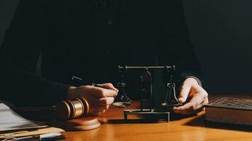 Business and lawyers discussing contract papers with brass scale on desk in office. Law, legal services, advice, justice and law concept picture with film grain effect video