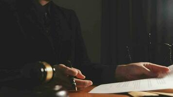 Justice and law concept.Male judge in a courtroom with the gavel, working with, computer and docking keyboard, eyeglasses, on table in morning light video