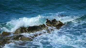 a mar a ondas batida em a pedras dentro lento movimento video