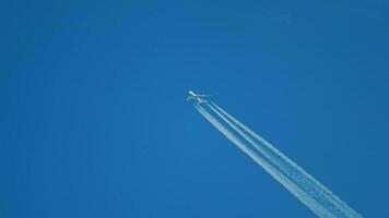 contrails in de blauwe lucht. vliegtuig dat hoog vliegt. video