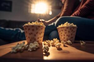 man and woman watching tv with the popcorn in the bucket with photo