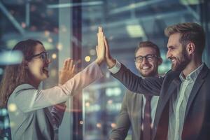 happy people are giving each other a high five in a bright business office with photo