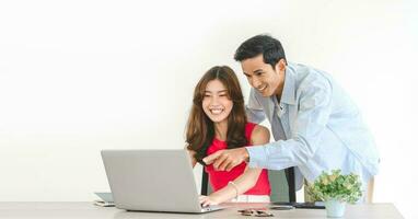 Young adult southeast asian couple man and woman using laptop computer at home photo