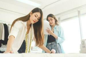 adulto asiático mujer Sastre diseñador haciendo ropa para negocio comienzo arriba estudio modista foto